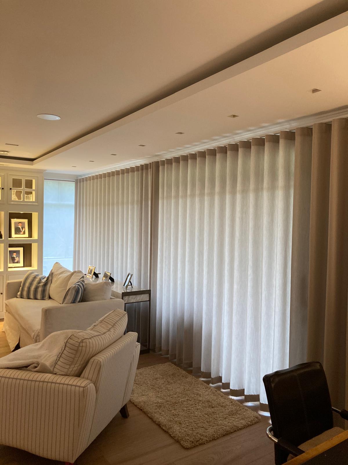 Floor-to-ceiling wave sheers fitted across a living room wall